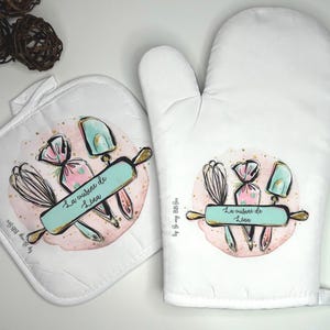 Peut inclure: Un ensemble de maniques et de dessous de plat blancs avec un motif aquarelle d'ustensiles de cuisine et le texte "La cuisine de Lisa".