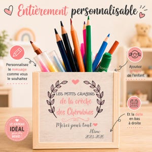 Puede incluir: Un portalápices de madera lleno de lápices y bolígrafos de colores. El portalápices tiene el texto "LES PETITS CRAYONS de la crèche des Chérubins" y "Merci pour tout". También es visible el texto "Eline 2023-2026".