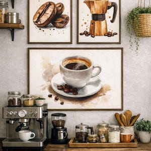 Può includere: Composizione a tema caffè con tre stampe incorniciate: chicchi di caffè, una caffettiera e una tazza di caffè. Una macchina per caffè espresso in acciaio inossidabile, un macinacaffè e vari accessori sono su un bancone di legno.