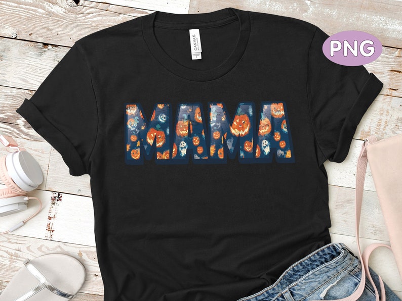 May include: Black t-shirt with the word "MAMA" spelled out in a pattern of orange and white jack-o'-lantern faces.