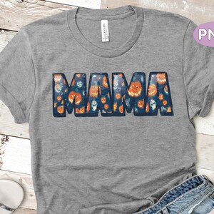 May include: A gray t-shirt with a graphic of the word "MAMA" made up of images of pumpkins and ghosts. The shirt has a distressed look.