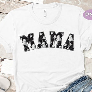 May include: White t-shirt with the word "MAMA" in black block letters. The letters are filled with a pattern of ghosts and bats. The shirt has short sleeves and a crew neck.