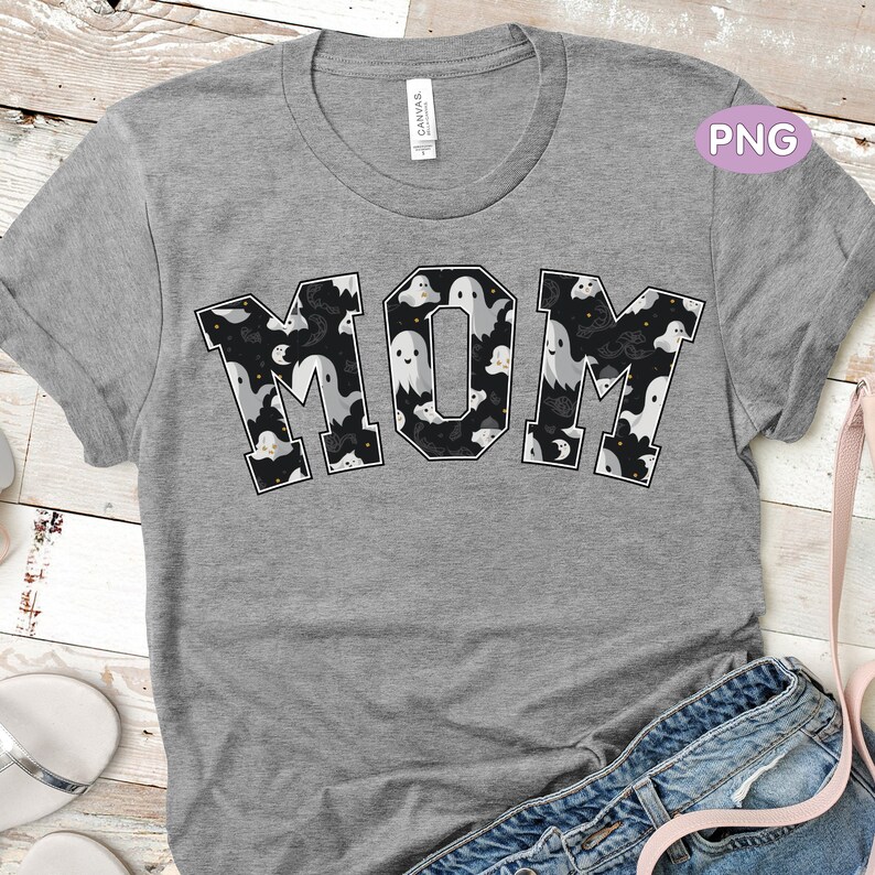 May include: A grey t-shirt with the word "MOM" printed in black outlined letters. The letters are filled with a pattern of white ghosts on a black background.