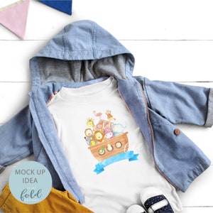 May include: A white toddler t-shirt featuring a watercolor illustration of Noah's Ark with various animals. The shirt is paired with a light blue hooded jacket, yellow pants, and navy blue and white shoes. The words "fold designs" are visible.