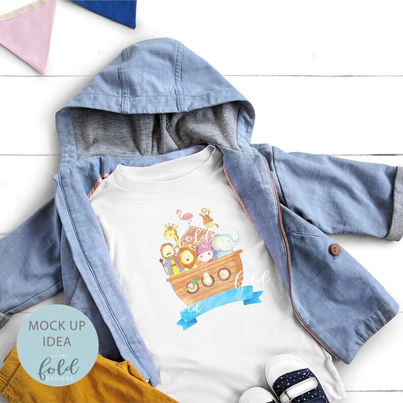 May include: A white toddler t-shirt featuring a watercolor illustration of Noah's Ark with various animals. The shirt is paired with a light blue hooded jacket, yellow pants, and navy blue and white shoes. The words "fold designs" are visible.