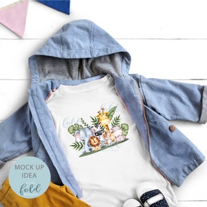 May include: White t-shirt with a graphic of a group of jungle animals including a giraffe, zebra, lion, elephant, and a monkey. The text "On the Fold Designs" is printed below the animals.