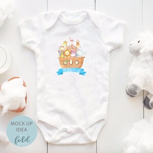 May include: White baby onesie with a watercolor illustration of Noah's Ark, featuring various animals. A blue banner below the ark has the word "hold" written on it. The onesie is a mock-up idea from "on the fold designs".