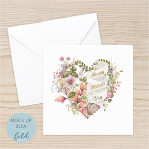 May include: A white card with a watercolor illustration of a heart-shaped arrangement of flowers and leaves. A white ribbon with the text "Happy Mother's Day" in gold lettering is wrapped around the flowers.
