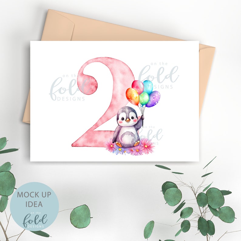 May include: A pink watercolor number two with a penguin holding colorful balloons. The text "on the fold designs" is in the top right corner of the card.