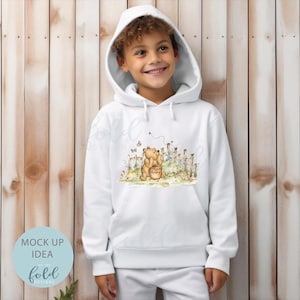 May include: White hooded sweatshirt featuring an illustration of Winnie the Pooh and Piglet. The illustration depicts Winnie the Pooh holding a honey pot with Piglet standing behind him. The illustration is surrounded by flowers and a fence.