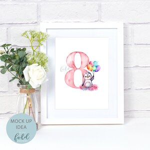 May include: A white frame with a pink watercolor number eight and a penguin holding colorful balloons. The penguin is sitting on a bed of pink flowers. The text "fold designs" is in the bottom left corner of the image.