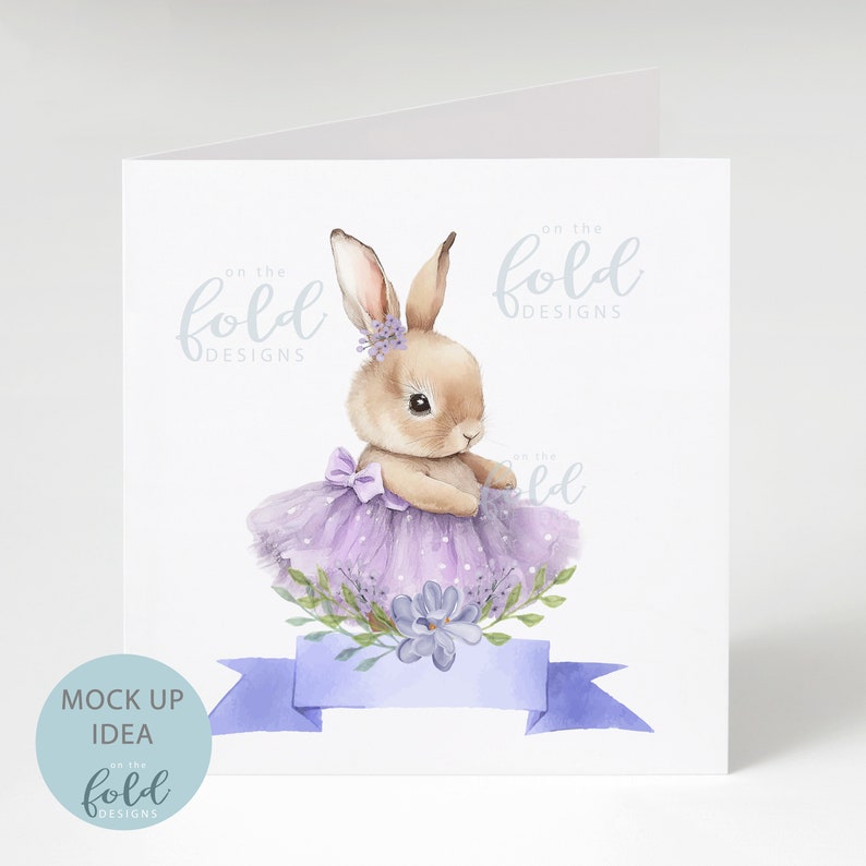 Peut inclure: Une illustration aquarelle d'un lapin brun portant un tutu violet et une couronne de fleurs. Le lapin est entour&eacute; de fleurs violettes et de feuilles vertes. Le texte "on the fold designs" est &eacute;crit en bleu clair en haut de la carte.