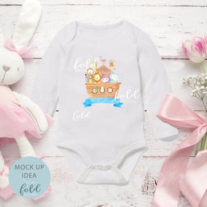 May include: White long-sleeve baby bodysuit featuring a watercolor illustration of Noah's Ark with various animals. The design includes a blue banner and the text "on the fold designs". A soft, comfortable garment for infants.