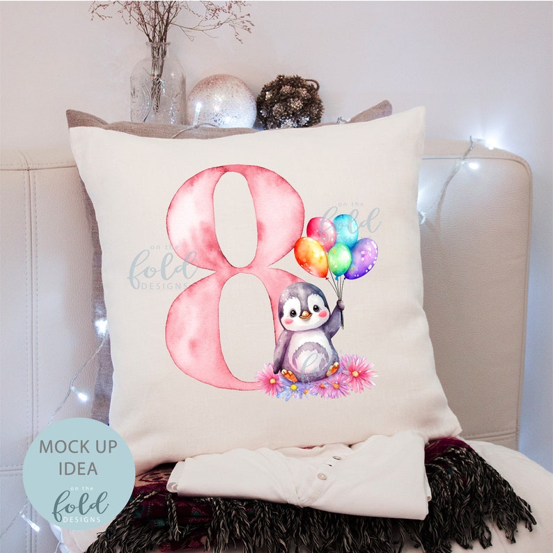 May include: A pink watercolor number eight with a penguin holding colorful balloons. The penguin is sitting on a bed of flowers. The text "On the Fold Designs" is in the corner of the image.