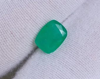 Puede incluir: Una gema verde vibrante con forma rectangular, cortada y pulida para la elaboración de joyas.