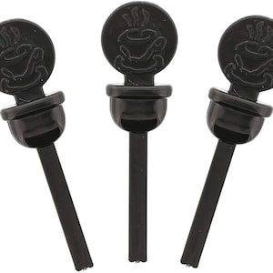 May include: Three black plastic bottle stoppers with a raised design of a coffee cup with steam coming from it.