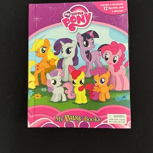 May include: A My Little Pony Busy Book with a pink cover featuring cartoon ponies. The book includes a storybook, 12 figurines, and a playmat. The cover has the words "My Little Pony" and "My Busy Books".