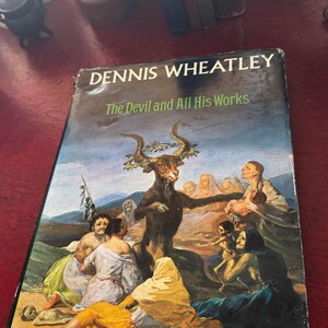 May include: A white ceramic mug with a black handle and the text "But First, Coffee" in a black, bold font. The mug is sitting on a wooden surface. The mug is 4 inches tall.