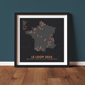 May include: Framed poster featuring a map of France with a cycling route marked in orange. The text "LE LOOP 2025" is at the bottom, with additional details about the event. The poster is in a black frame.