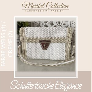 Può includere: Una borsa a tracolla in crochet bianco e crema con una chiusura argentata. La borsa ha una tracolla e il testo "FARBE WEISS (1) / CREME (2)" è sul lato sinistro dell'immagine. Il testo "Maribel Collection HANDMADE WITH PASSION" è nella parte superiore dell'immagine. Il testo "Schultertasche Elegance" è nella parte inferiore dell'immagine.