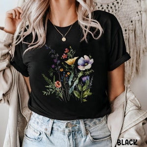 Op de afbeelding: Zwart T-shirt met een kleurrijke bloemenprint met verschillende bloemen, waaronder gele, paarse en roze.