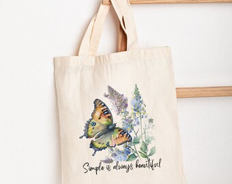May include: A white canvas tote bag with a watercolor illustration of a butterfly and flowers. The text "Simple is always beautiful" is printed on the bag.
