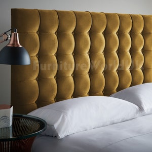 May include: A mustard yellow velvet headboard with a tufted design. The headboard is on a bed with white linens and pillows.