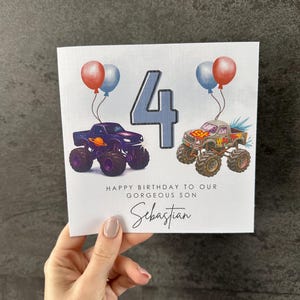 May include: Birthday card with monster truck illustrations, balloons, and the number 4. The text says "Happy Birthday to our gorgeous son Sebastian."