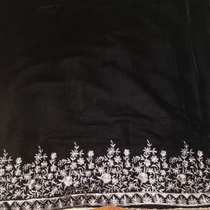 May include: Black velvet fabric with a silver embroidered floral border.
