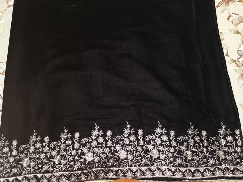 May include: Black velvet fabric with a silver embroidered floral border.