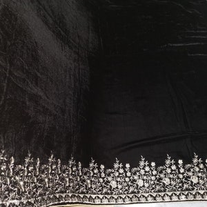 May include: Black velvet shawl with a silver embroidered border featuring a floral design.
