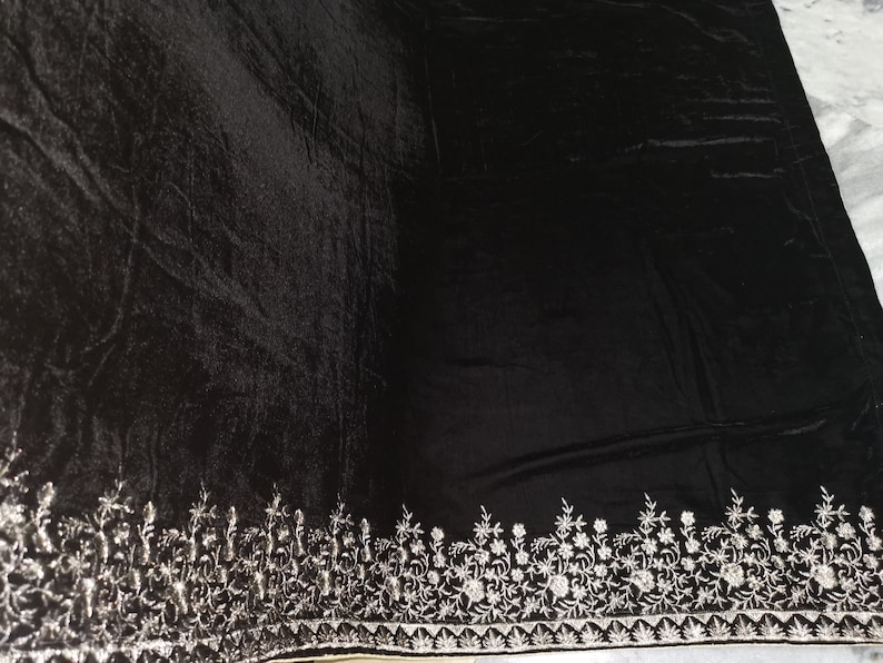 May include: Black velvet shawl with a silver embroidered border featuring a floral design.