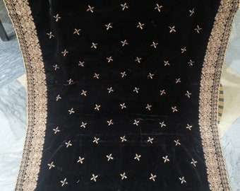May include: Black velvet shawl with gold embroidery in a floral pattern. The shawl has a decorative border with a gold thread design.