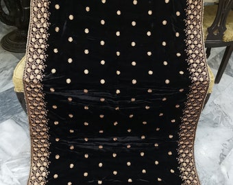 May include: A black velvet shawl with gold embroidery. The shawl features a floral pattern and is decorated with small gold dots.