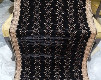May include: Black velvet shawl with a gold embroidered floral pattern. The shawl has a decorative border with a gold lace trim.