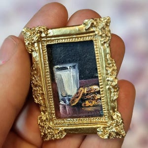 Miniatura de pintura al óleo con imán: arte culinario realista de leche y galletas en marco dorado. Obra navideña única (2 x 3 cm).