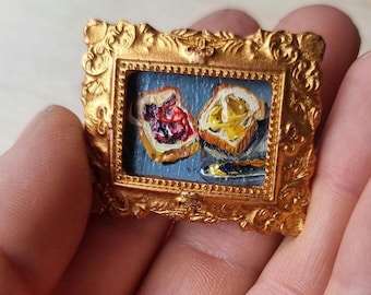 Miniatuurolieverfschilderij: toast met jam en pindakaas in gouden lijst
