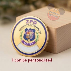 May include: A gold-colored ZPD Officer badge with a blue and purple emblem featuring a fox and rabbit. The badge has the text "ZOOTOPIA POLICE DEPARMENT" and "OFFICER". The text "I can be personalised" is below the badge.