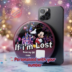 Peut inclure: Un accessoire de téléphone rond et personnalisé avec Mickey Mouse, un château et le texte "If I'm Lost". L'accessoire est conçu pour être fixé à un smartphone. Le texte "Scan my QR code" est également inclus.