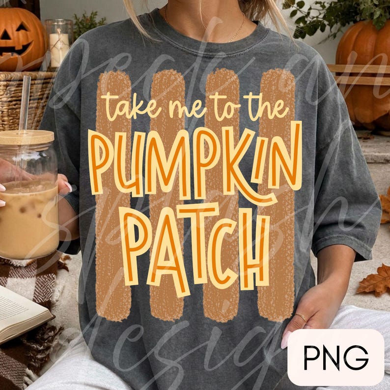 May include: A charcoal gray short-sleeve t-shirt featuring a graphic print with four vertical textured tan stripes. The text reads take me to the PUMPKIN PATCH in a mix of cursive and bold orange lettering centered over the stripes.