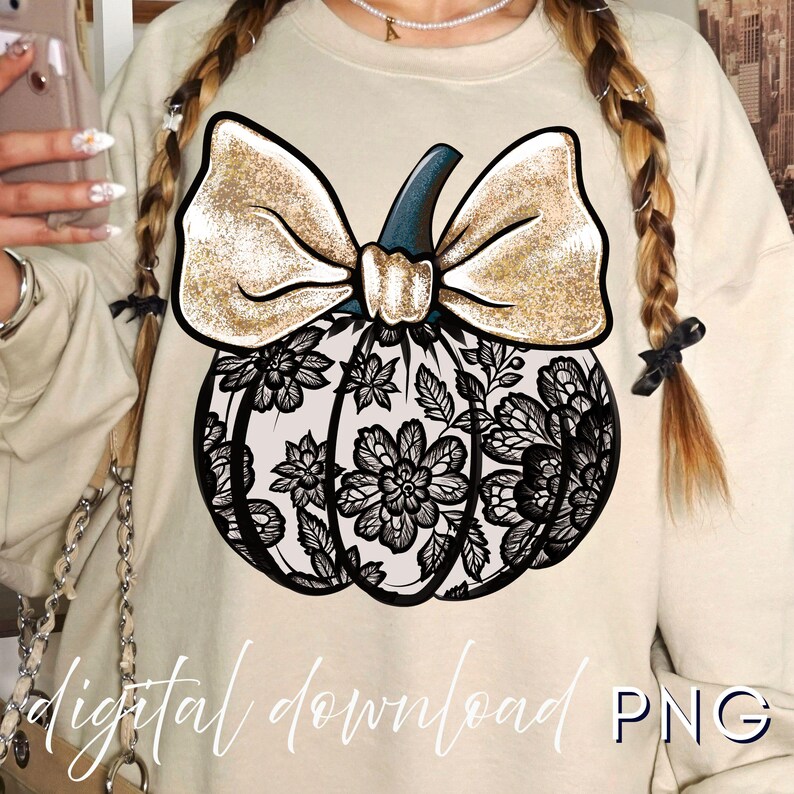 May include: Beige sweatshirt featuring a pumpkin design. The pumpkin has a black floral lace pattern, a gold bow, and a dark blue stem. The words "digital download PNG" are written at the bottom.