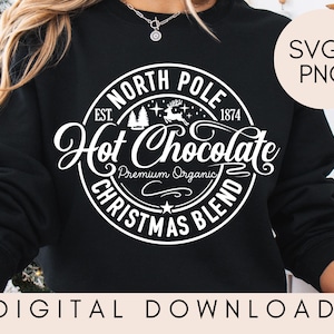 May include: A black sweatshirt with a white graphic design that says "North Pole Hot Chocolate Christmas Blend" with a reindeer and pine trees. The text also says "Est. 1874" and "Premium Organic".