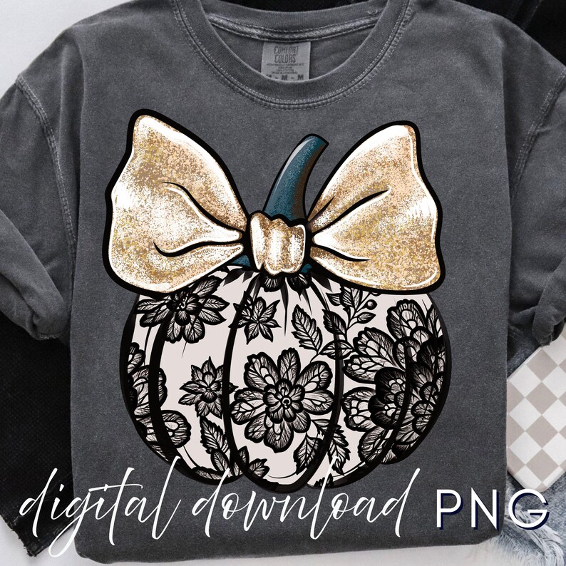 May include: Dark gray sweatshirt featuring a pumpkin design. The pumpkin has a cream-colored base with black floral lace detailing. A large gold glitter bow sits atop the pumpkin, with a teal stem. The words "digital download PNG" are written in white script.