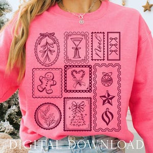 May include: A bright pink sweatshirt featuring a collection of Christmas-themed postage stamp designs in dark pink. The stamps include a gingerbread man, Christmas tree, ornaments, and the word "Noel". The words "DIGITAL DOWNLOAD" are at the bottom.
