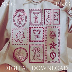 May include: Cream-colored sweatshirt featuring a collection of red Christmas-themed postage stamp designs. The stamps depict festive elements like a gingerbread man, candy canes, and a Christmas tree. The text "DIGITAL DOWNLOAD" is at the bottom.