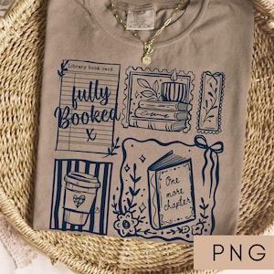 May include: A tan t-shirt with a dark blue graphic design featuring a library book card, coffee cup, books, and the words "fully booked" and "One more chapter." The shirt is displayed on a woven basket.