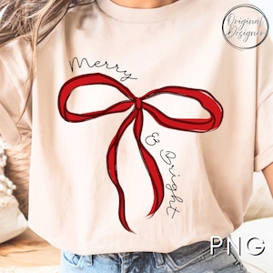 Könnte beinhalten: Beiges T-Shirt mit großem rotem Schleifendesign und den Worten "Merry & Bright" in schwarzer Schrift. Das Design hat eine handgezeichnete Ästhetik, perfekt für die Weihnachtszeit. Das Shirt hat auch ein "Original Designer" Logo.