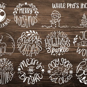 May include: A collection of white Christmas-themed graphics on a dark wood background. The designs include phrases like "Merry Christmas," "Happy Holidays," and "Joy to the World," along with festive illustrations of a snowman, deer, and Christmas tree.