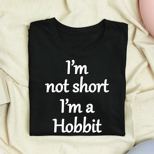 May include: Black t-shirt with white text that reads "I'm not short I'm a Hobbit".