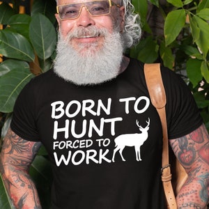 May include: Black t-shirt with white text that reads "Born to Hunt Forced to Work" and a white silhouette of a deer with antlers.
